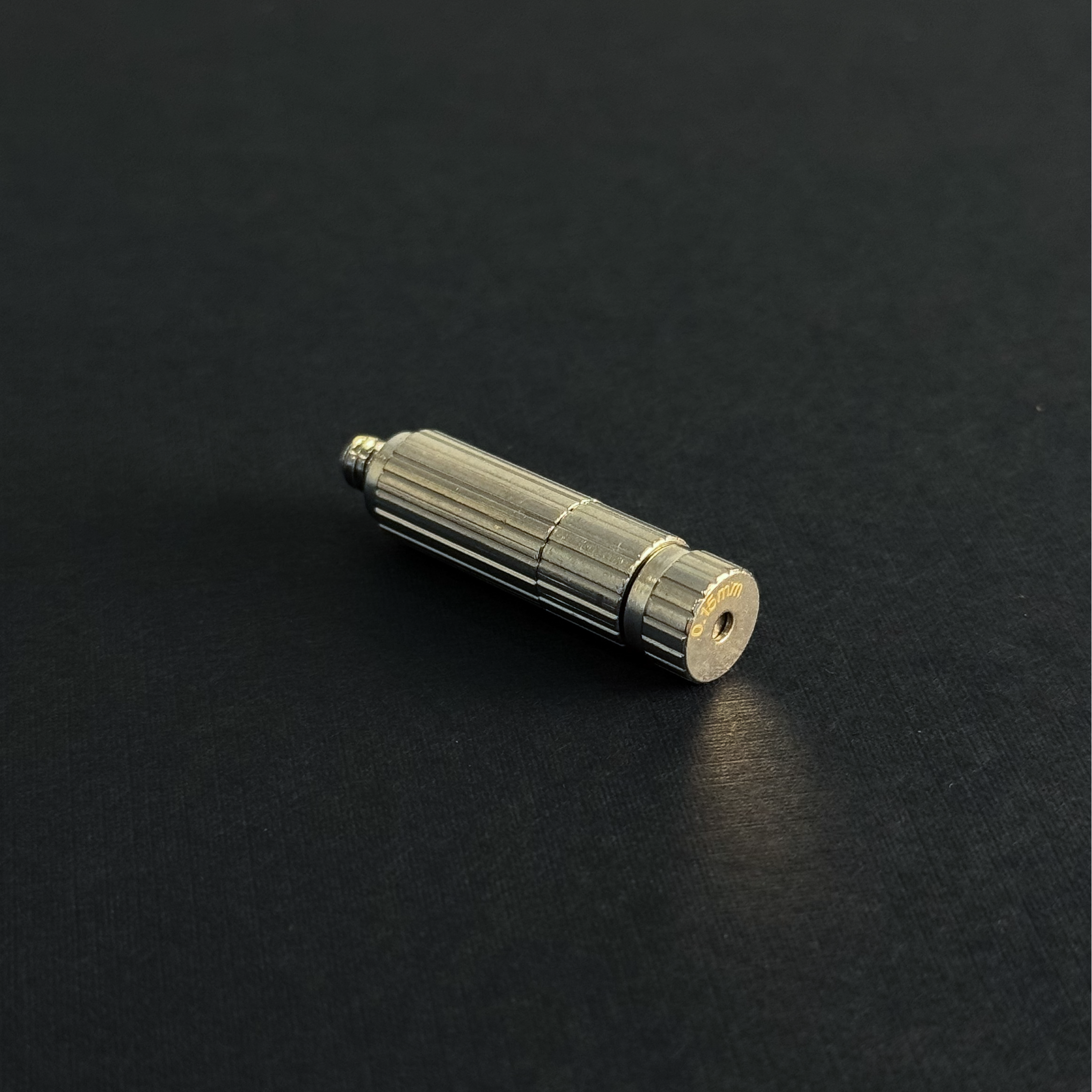 A nozzle for a high pressure misting system on a dark background