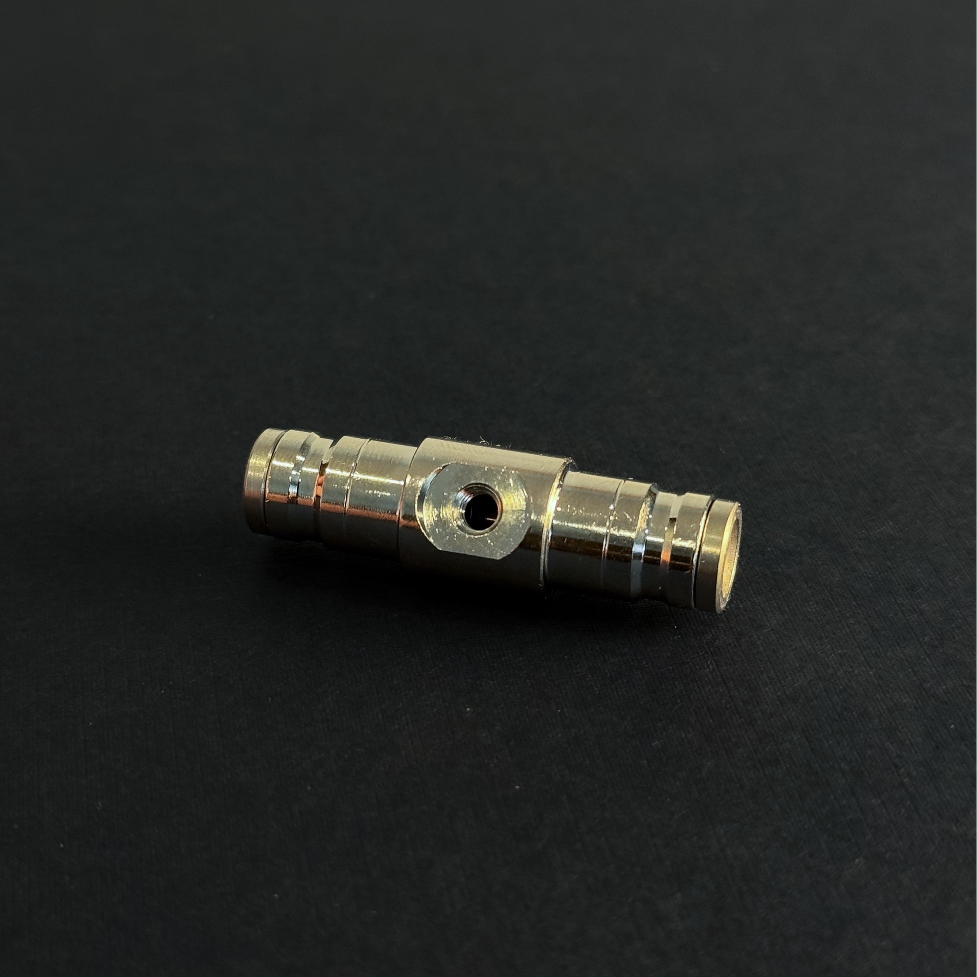 A quick connect fitting for a high pressure misting system on a dark background